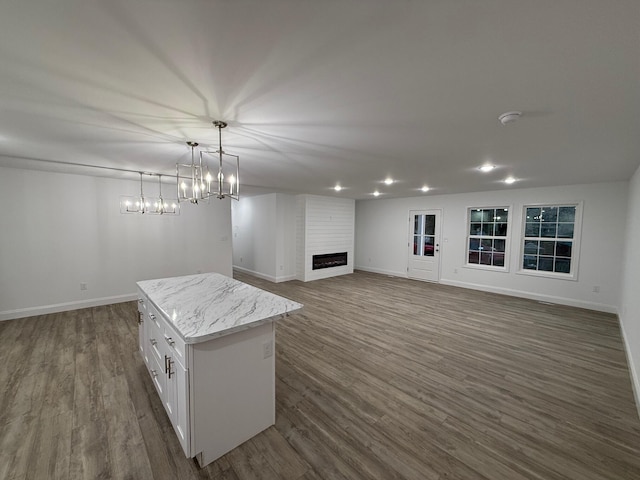 interior space featuring a fireplace, dark wood-type flooring, and a chandelier