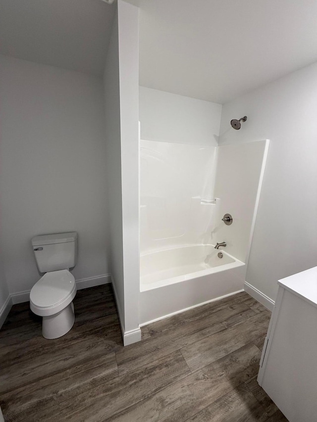 full bathroom with hardwood / wood-style floors, vanity, bathtub / shower combination, and toilet