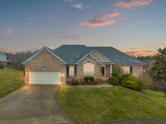 view of front of home with a garage and a lawn