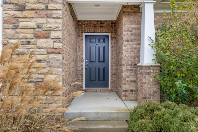 view of exterior entry featuring brick siding