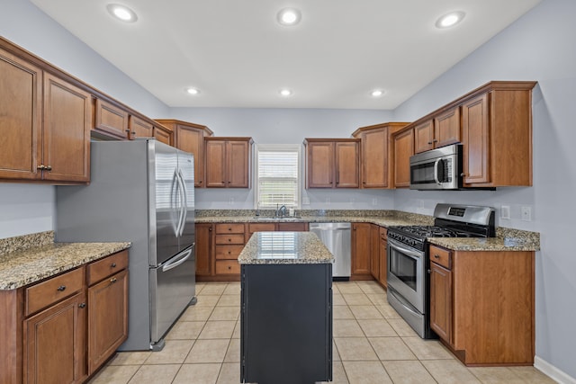 kitchen with sink, a center island, light tile patterned floors, stainless steel appliances, and light stone countertops