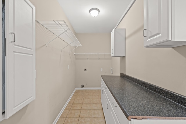 laundry area featuring cabinets, light tile patterned floors, and electric dryer hookup