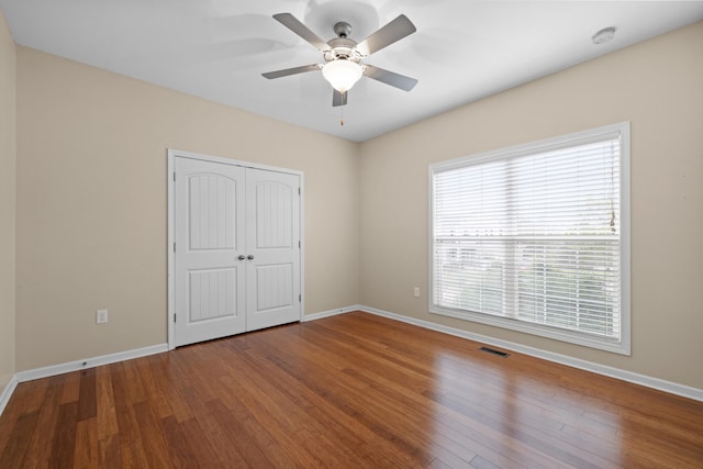 unfurnished bedroom with visible vents, baseboards, and wood finished floors