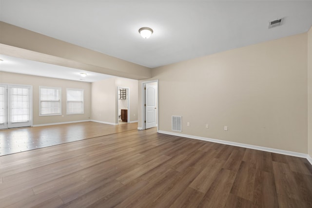 unfurnished room featuring visible vents, baseboards, and wood finished floors