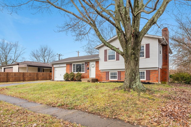 split level home with a garage and a front lawn