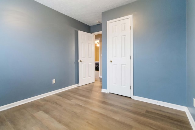 unfurnished bedroom with hardwood / wood-style floors and a textured ceiling