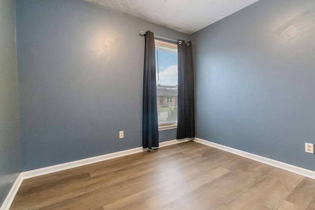 spare room with hardwood / wood-style floors and a textured ceiling