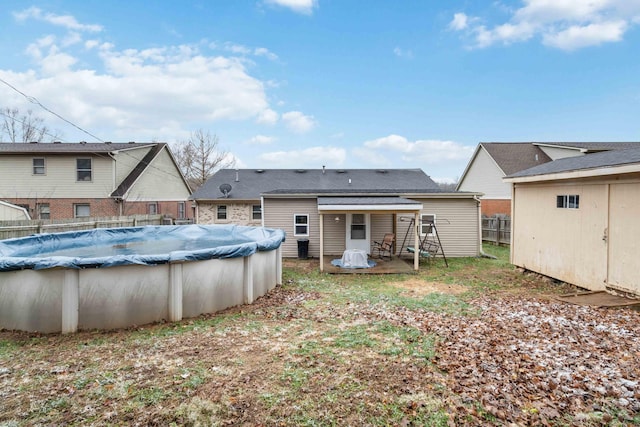 rear view of property with a covered pool