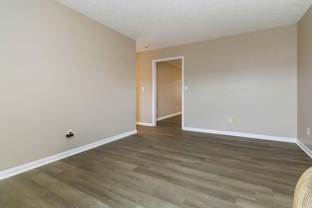 empty room with dark hardwood / wood-style flooring