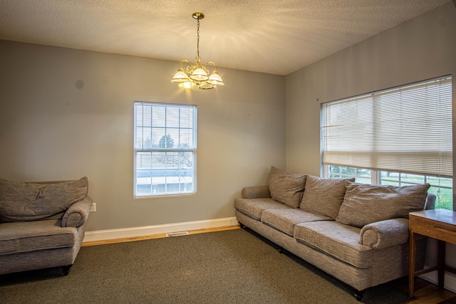 living room with a textured ceiling, plenty of natural light, and a notable chandelier