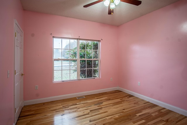 spare room featuring ceiling fan, a textured ceiling, and light wood-type flooring