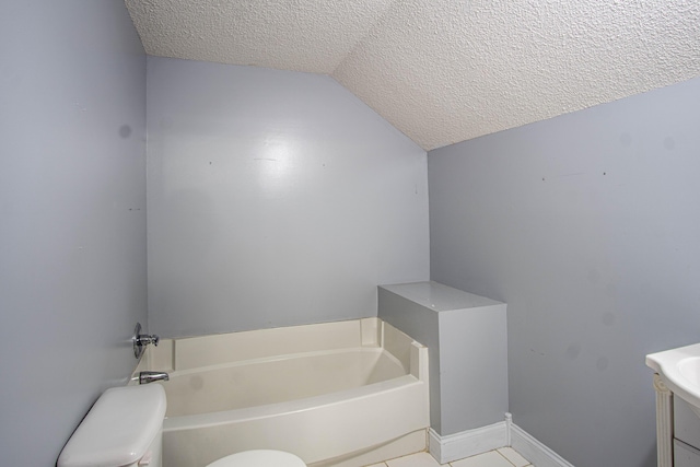 bathroom with vaulted ceiling, a bathing tub, a textured ceiling, and toilet