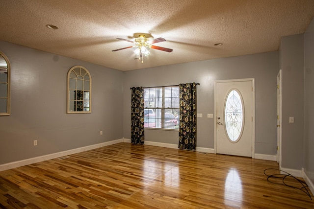 entrance foyer featuring wood-type flooring, a textured ceiling, and ceiling fan