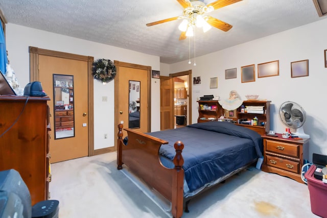 carpeted bedroom featuring a textured ceiling and ceiling fan