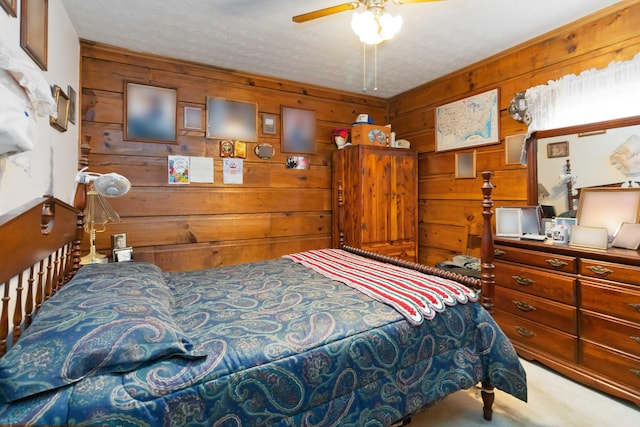 carpeted bedroom featuring wood walls, ceiling fan, and a textured ceiling