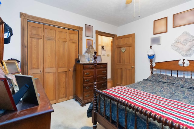 carpeted bedroom featuring ceiling fan, a closet, and a textured ceiling