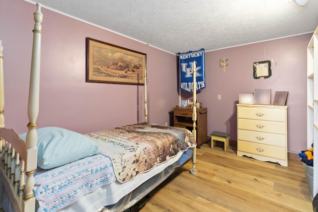 bedroom featuring light hardwood / wood-style floors and a textured ceiling