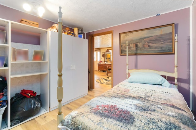 bedroom featuring a textured ceiling and light hardwood / wood-style flooring