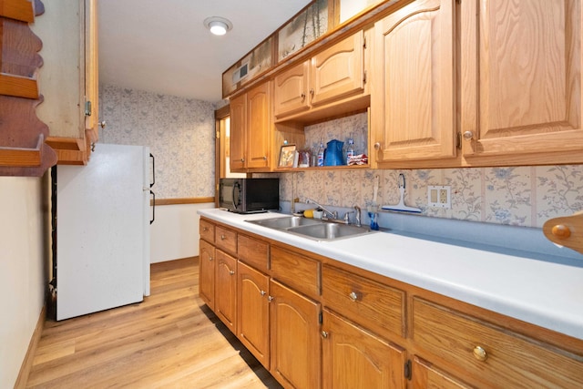 kitchen with sink, white fridge, and light wood-type flooring