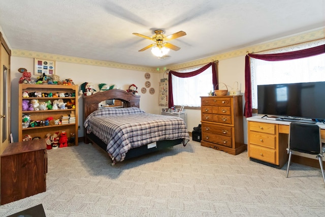 carpeted bedroom featuring a textured ceiling and ceiling fan