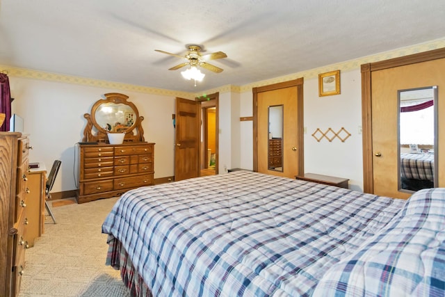 carpeted bedroom featuring ceiling fan and a textured ceiling