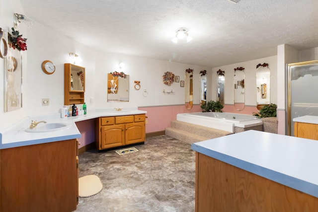 bathroom with vanity, independent shower and bath, and a textured ceiling