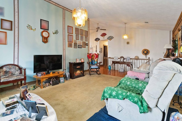 carpeted living room with ceiling fan with notable chandelier and lofted ceiling