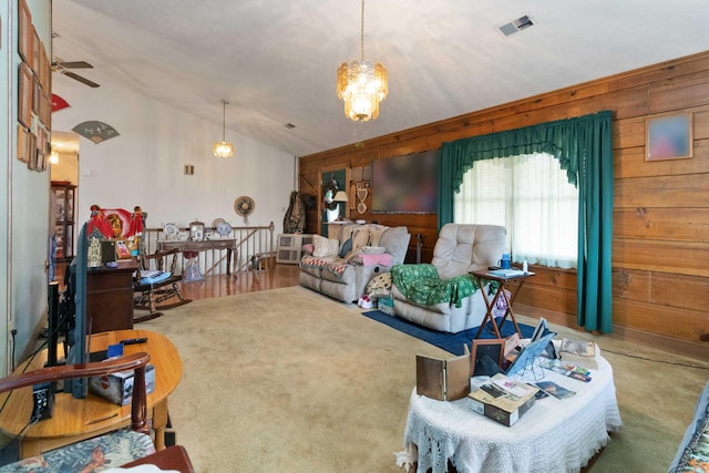 carpeted living room with wooden walls, ceiling fan, and lofted ceiling