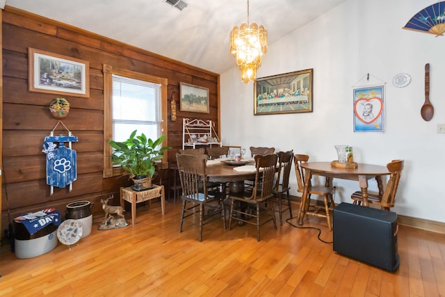 dining room with lofted ceiling, wood-type flooring, and a chandelier