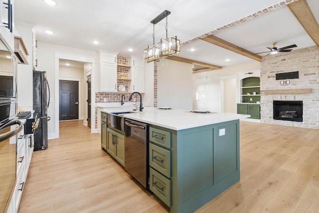 kitchen featuring stainless steel appliances, white cabinetry, a kitchen island with sink, and decorative light fixtures