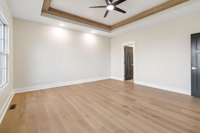 empty room with ceiling fan, a tray ceiling, light hardwood / wood-style floors, and wooden ceiling