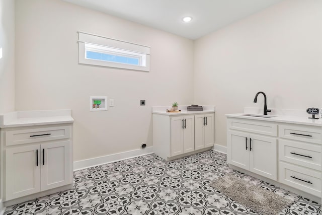 laundry area featuring sink, cabinets, light tile patterned floors, hookup for a washing machine, and hookup for an electric dryer