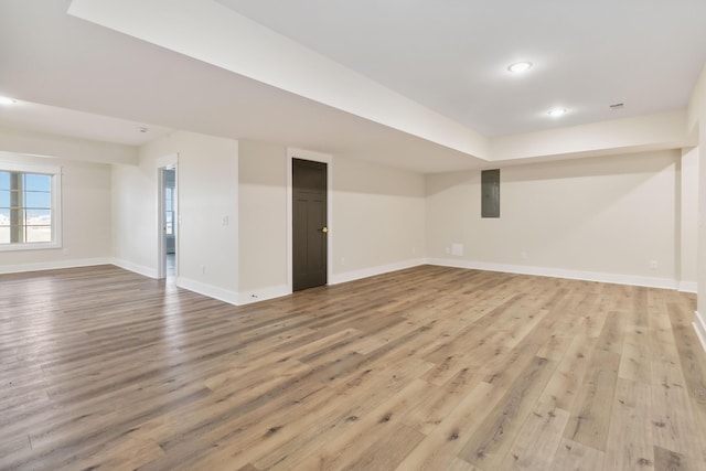 basement with electric panel and light wood-type flooring