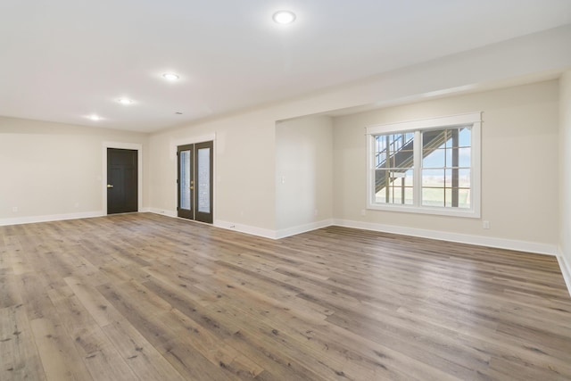 spare room with light hardwood / wood-style floors and french doors