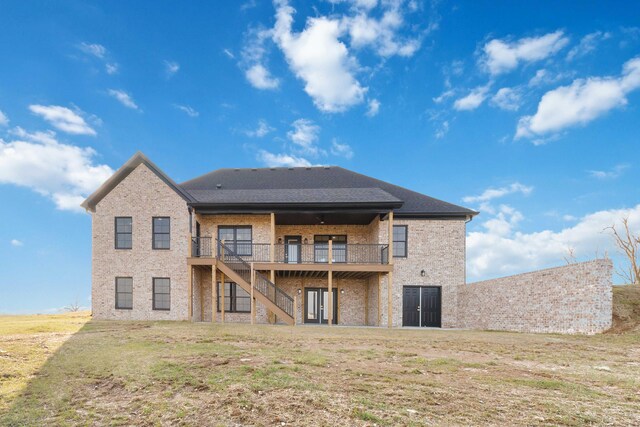 rear view of house featuring a wooden deck and a yard