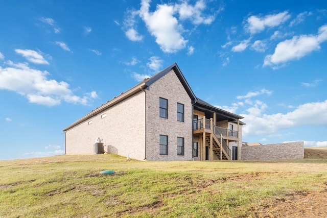 rear view of property featuring cooling unit and a lawn