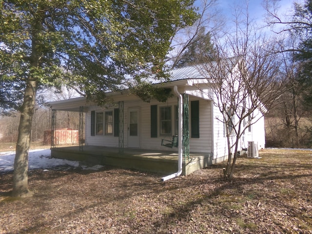 view of front of home featuring covered porch, metal roof, and central AC