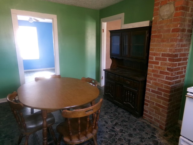 dining area with baseboards and a textured ceiling