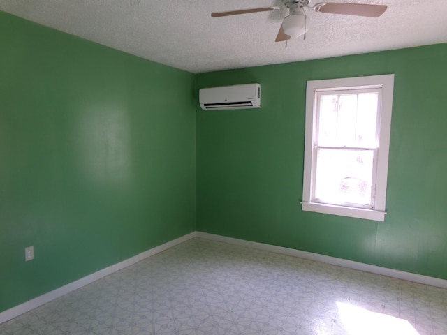 spare room with a healthy amount of sunlight, light floors, baseboards, and a wall mounted air conditioner