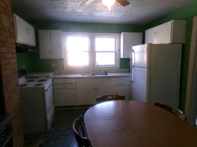 kitchen with white appliances, white cabinets, light countertops, under cabinet range hood, and a sink