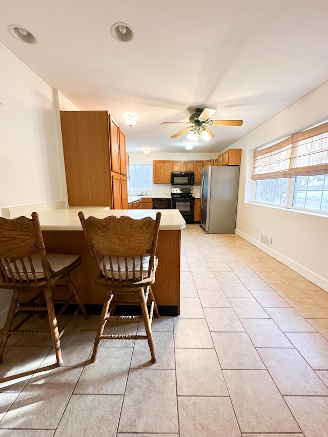 tiled dining space with a wealth of natural light and ceiling fan