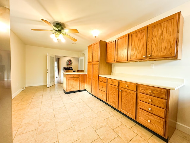 kitchen featuring light tile patterned floors, kitchen peninsula, and ceiling fan