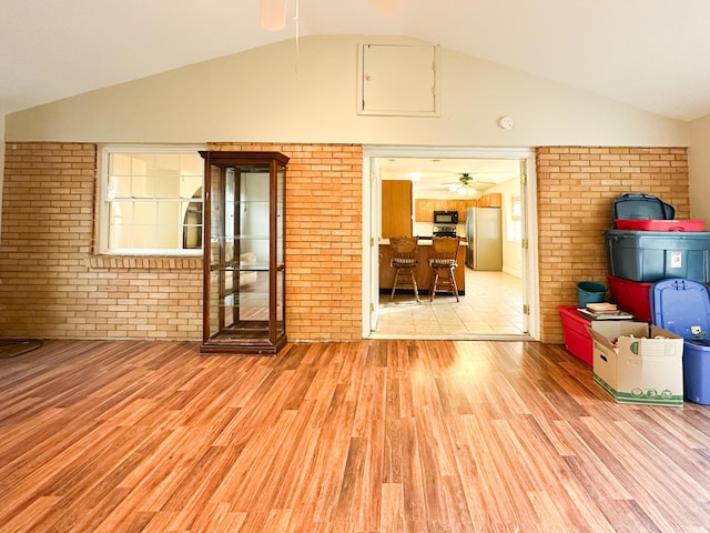 interior space with lofted ceiling, ceiling fan, and light wood-type flooring