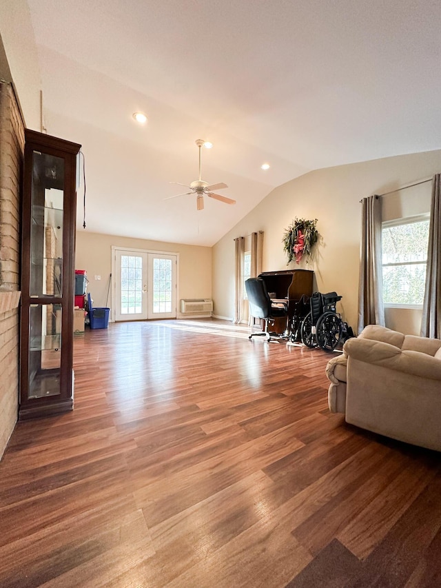 living room with french doors, a healthy amount of sunlight, vaulted ceiling, and hardwood / wood-style flooring