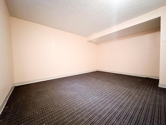 carpeted spare room with a textured ceiling