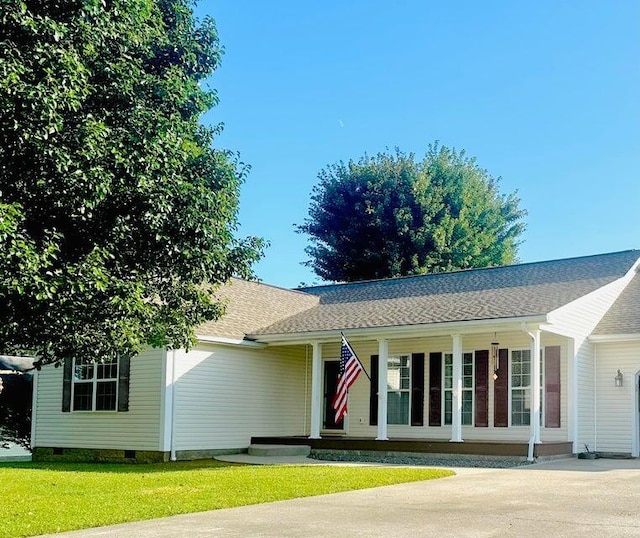 ranch-style house featuring covered porch and a front yard