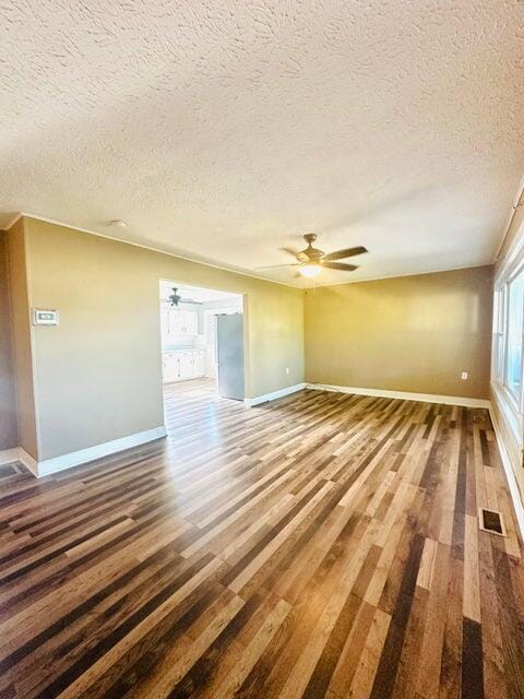 unfurnished living room featuring hardwood / wood-style floors and a textured ceiling