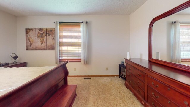 carpeted bedroom with multiple windows, ceiling fan, and a textured ceiling