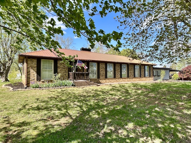 ranch-style home featuring brick siding, a front lawn, and metal roof