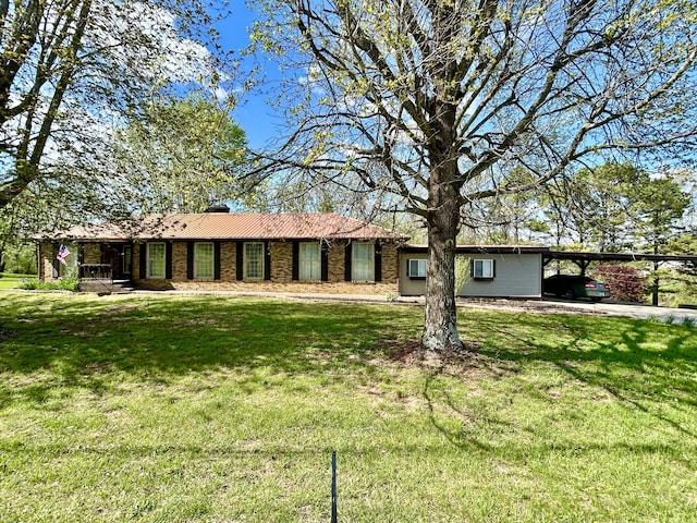 rear view of property with a carport and a lawn